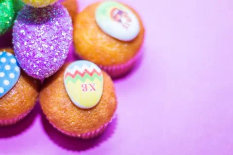 On a pink background close-up of colored Easter eggs and cupcake, holiday bac Stock Photos