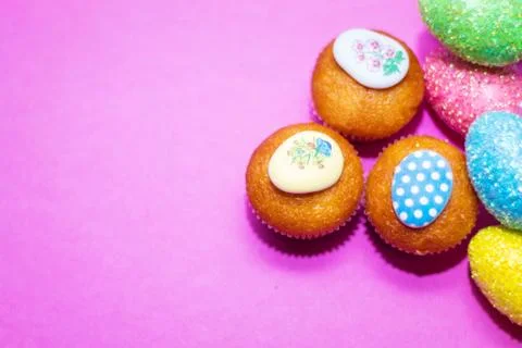 On a pink background close-up of colored Easter eggs and cupcake, holiday bac Stock Photos