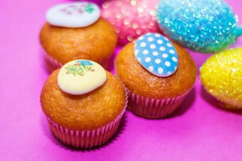 On a pink background close-up of colored Easter eggs and cupcake, holiday bac Stock Photos