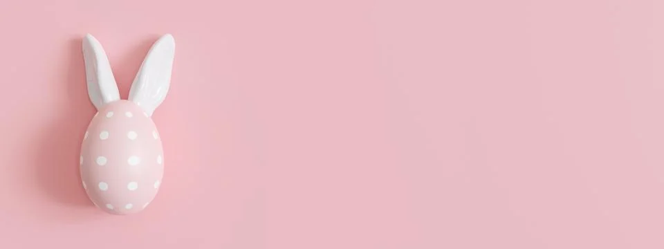 Pink background with Easter egg, rabbit ears and copy space. Easter backdrop Stockillustratie