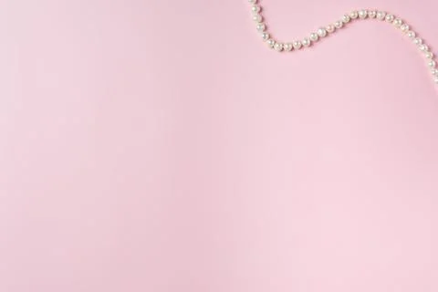 Pink background with string of pearls. Copy space Stock Photos