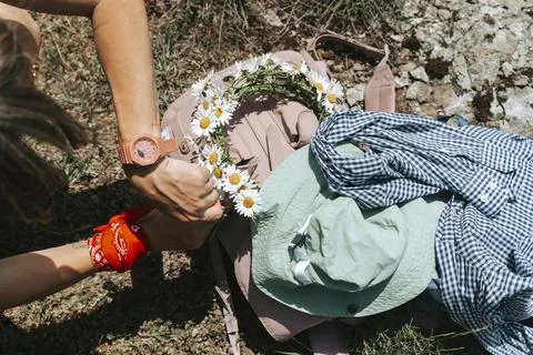 Pink backpack with a daisy crown and sun hat in a meadow. Stock Photos