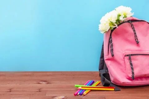 In a pink backpack flowers, colored pencils on the table, preparing for schoo Stock Photos