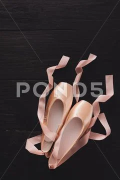 Pink ballet pointe shoes on black wood background Stock Photos