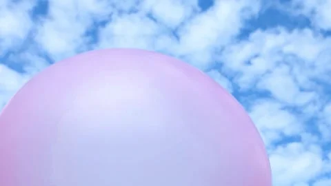 Pink balloon floating high under cloudy sky Stock Footage 317422194