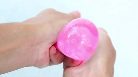 Pink balloon squeezed and stretched by hands Video stock 317399453