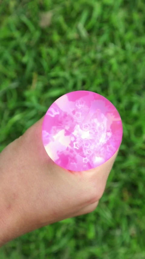 Pink balloon squeezed in hands outdoors Stock Footage 320393633