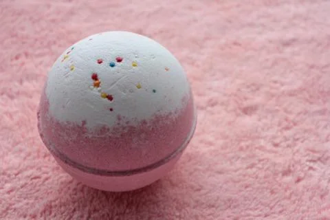 Pink bath bomb on soft towel texture background. Stock Photos