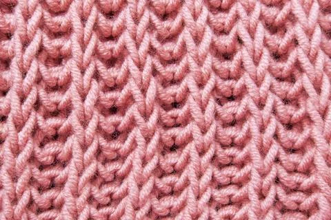 Pink beautiful knitted braid pattern of light natural wool yarn, knitted te.. Stock Photos