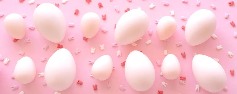 Pink Big and small Easter eggs and confetti on pink background. Egg hunting. Foto stock