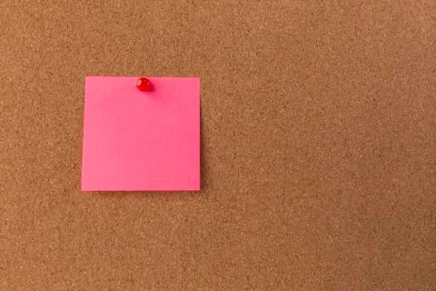 Pink Blank sticky notes red pinned into brown corkboard. close up Stock Photos