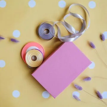 Pink box in festive decor. Spring, summer. Place for logo and text. Top view Foto stock
