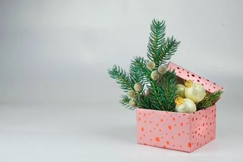 Pink box with golden christmas balls and green branches of christmas tree Stock Photos