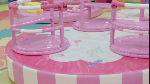 Pink bright carousel round empty merry-go-round plastic swing indoors spinning Stock Footage 219757945