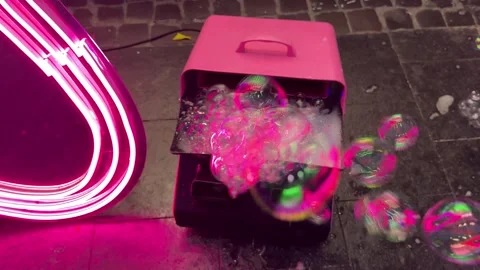 Pink bubble machine blowing soap bubbles near neon light Stock-Footage 314398354