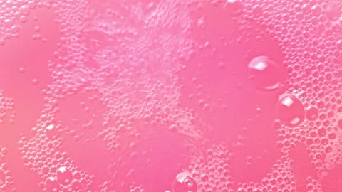 Pink bubbling liquid boiling texture. Carbonated drink background. Stock Footage 147386928