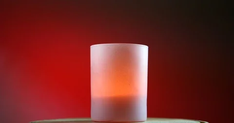 Pink burning candle on red gradient background rotates on the wooden platform Stock-Footage 91630111
