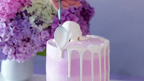 Pink cake is covered with white liquid icing. Stock Footage 152342717