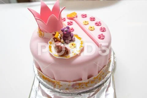 Pink cake of a little princess with a crown and animal figures. Birthday one Stock Photos