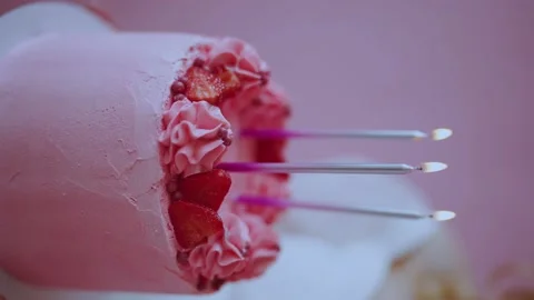 Pink cake with three burning candles for a birthday, vertical video Stock Footage 196115401