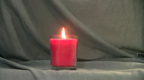 Pink candle's flame grows then is blown out against a blue background Video stock 35533309