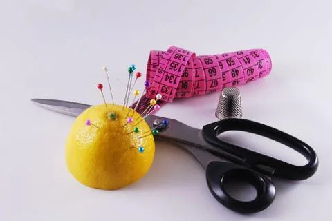 Pink centimeter and scissors and pincushion of lemon Stock Photos