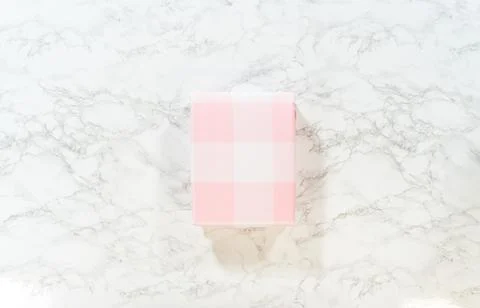 Pink checkered gift box on marble background 写真素材