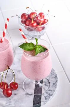 Pink cherry smoothies with fresh red berry, chia seeds, mint green leaves, wh Stock Photos