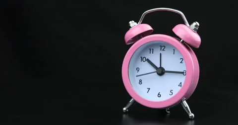 Pink clock with black numbers and arrows on black background, Time Lapse Stock Footage 108344475