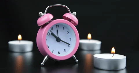 Pink clock with black numbers and arrows on black background Stock Footage 108344586