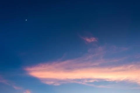 Pink cloud and moon in blue sky Stock Photos