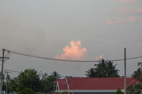 Pink Cloud Formation Over Tropical Rooftops Stock Photos