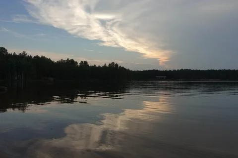Pink clouds are reflected in the forest lake. Camping, recreation, hobby Stock Photos