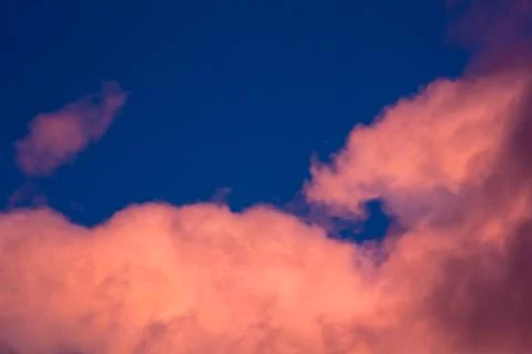 Pink clouds on a background of blue sky at sunset Stock Photos