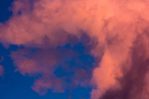 Pink clouds on a background of blue sky at sunset Stock Photos