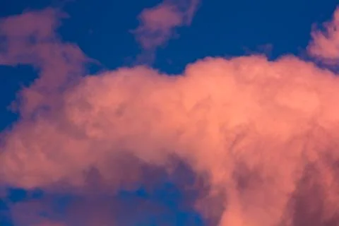 Pink clouds on a background of blue sky at sunset Stock Photos