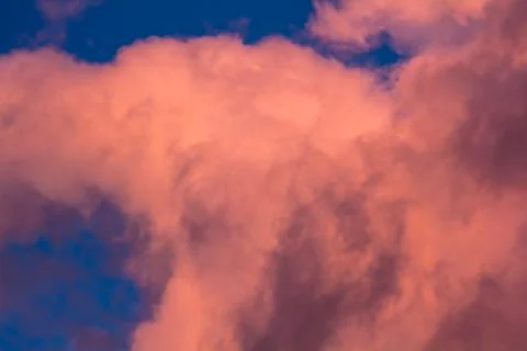 Pink clouds on a background of blue sky at sunset Stock Photos