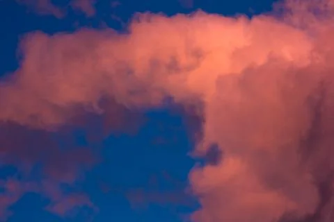 Pink clouds on a background of blue sky at sunset Stock Photos