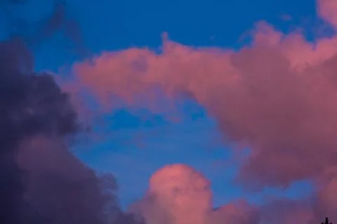 Pink clouds on a background of blue sky at sunset Stock Photos