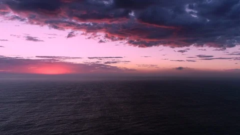 Pink clouds at dawn over ocean Stock Footage 107058496