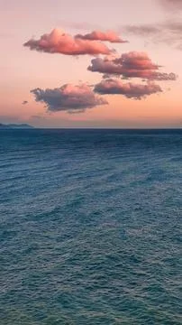 Pink clouds in evening sky over blue sea, twilight fabulous sunset, copy space Stock Photos