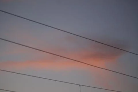 Pink clouds in an evening sky with power lines Stock Photos