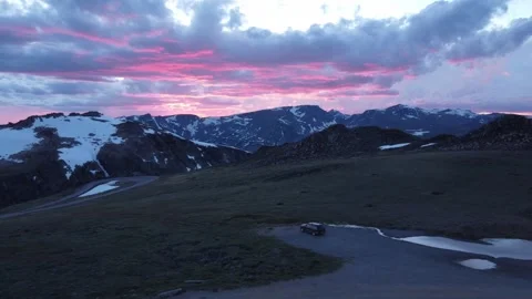 Pink clouds over black SUV parked on mountain pass 스톡 동영상 312032126