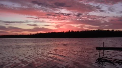 Pink clouds &amp; reflection in lake water, lake country sunset with dock Stock Footage 292815240