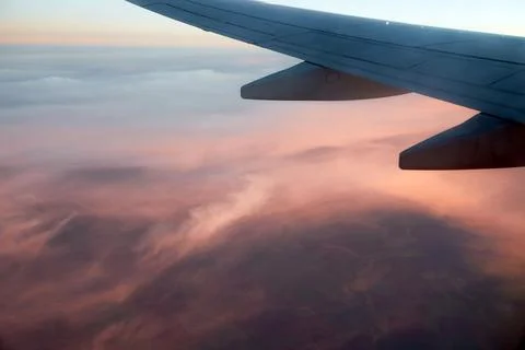 Pink clouds under the wing of an airplane. Foto stock