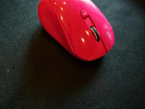 A pink colored mouse above a table in the living room. 库存照片