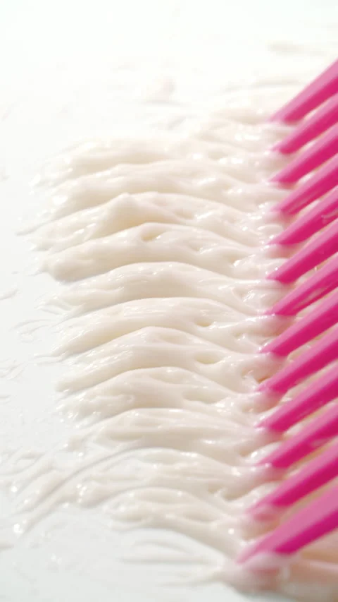 Pink comb creating wave pattern in cream Stock Footage 311025781