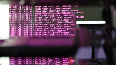 Pink computer software code moving on a black monitor reflect on glass. Abstr Stock Footage 143871173