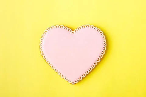 Pink cookie heart shaped with different patterns, yellow background Stock Photos