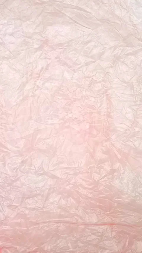 Pink crumpled plastic bag texture background rotating. Low-Density Polyethylene Stock Footage 316381225